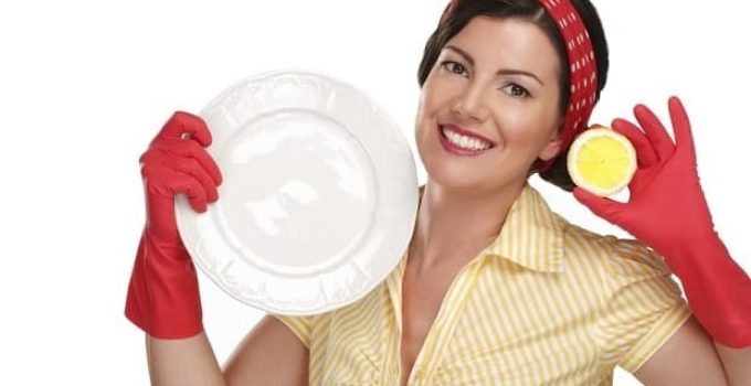 Vintage woman with rubber gloves holding plate and lemon