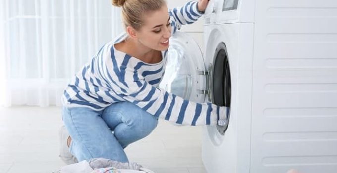 Woman taking laundry out of clothes dryer