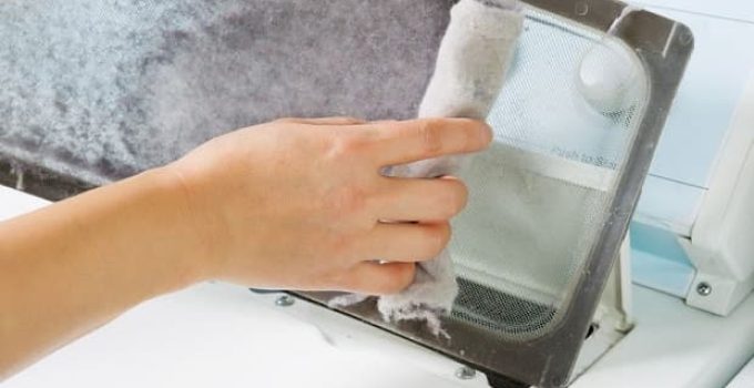 Woman cleaning clothes dryer lint trap